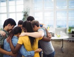 Group of business executives forming huddle Group of happy business executives forming huddle in office